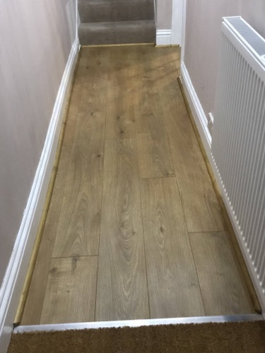 Laminate entrance hall with custom front door rug and trim