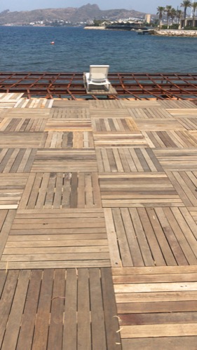 Near complete beach club deck. Repurposed old decking to create new, durable design of deck tiles. Ugur Bolat designed, project managed and oversaw team to install entire deck